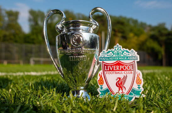 August 30, 2021, Liverpool, UK. Liverpool F.C. Football Club emblem and the UEFA Champions League Cup on the green turf of the stadium.