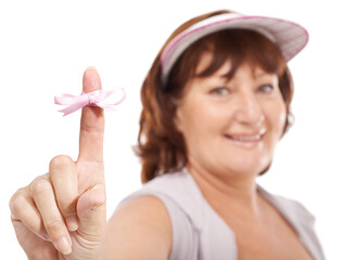 Breast cancer awareness. Mature woman showing you breast cancer awareness ribbon against a white background.