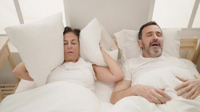 Man and woman couple sleeping on bed snoring at bedroom