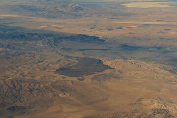 Aerial view of the deserts in the western United States featuring Canyons, rock formations, clouds and parceled farmland