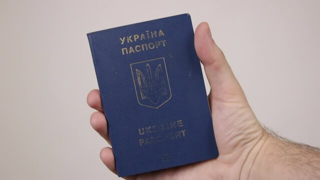 Blue passport of Ukraine male hand holding a document. The concept of tourism, travel, air travel, nationality