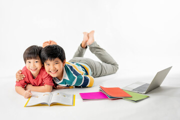 Portrait of Happy asian boys, Brother on floor with laptop and books isolated on white background, Education and learning with technology concept