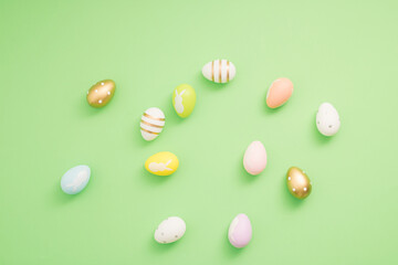 Fototapeta na wymiar Pattern made of colorful Easter eggs on pastel green background. Minimal Easter or food concept.