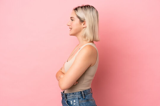 Young caucasian woman isolated on pink background in lateral position