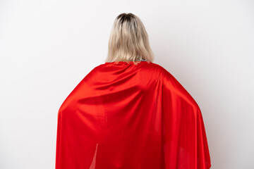 Young caucasian woman isolated on white background in superhero costume in back position © luismolinero