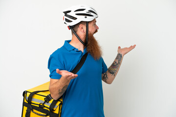 Young reddish caucasian man with thermal backpack isolate don white background with surprise expression while looking side