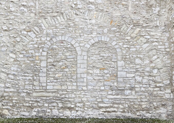 Old rustic monastery wall, with bricked up window.