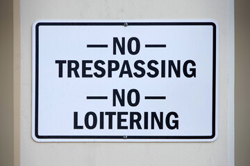 NO TRESPASSING NO LOITERING sign on a building wall