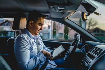 One man young adult manager or sales director business person sitting on the front seat of car...
