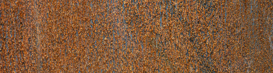 Flat sheet of iron with pattern and texture in orange rust from extensive oxidation, as an abstract background
