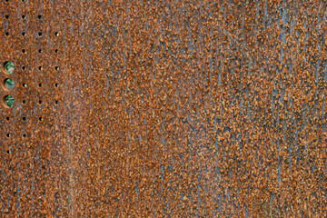 Flat sheet of iron with pattern and texture in orange rust from extensive oxidation, as an abstract background

