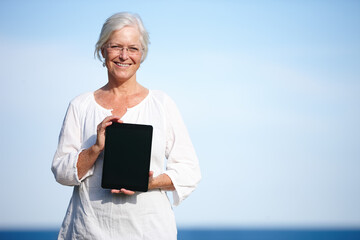 Shes found some great relaxation exercises online. Portrait of a mature woman holding up a digital...