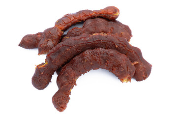 Pile of tamarind fruits on white background. Top view. Flat lay.
Sticky brown acidic pulp from the pod of a tree of the pea family, widely used as a flavoring in Asian cooking.