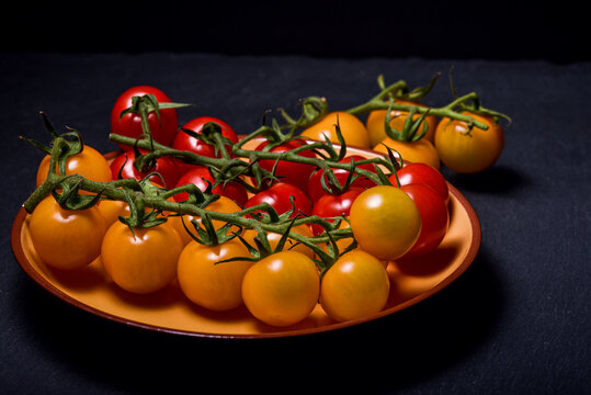 Mini red and yellow  tomatoes on a dark  background scenarios. Food photography