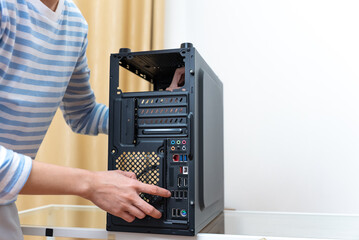 Hands of woman laying out a gaming computer motherboard in a black case.