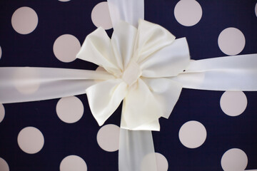 Gift box wrapped in polka dot paper and a ribbon bow