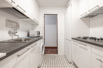 Kitchen with white furniture, gas stove, refrigerator and white washing machine and tile floor