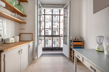 Kitchen decorated in a vintage way with a balcony with a glass screen and wrought iron