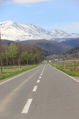 初夏の田舎の道と残雪の山
