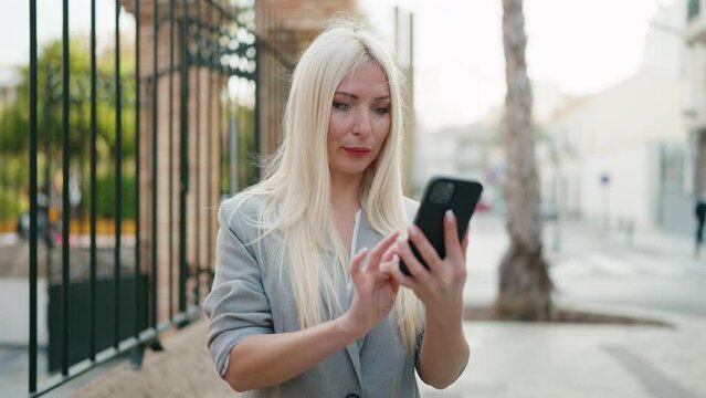 Young blonde woman executive making selfie by the smartphone at street