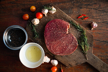 Sliced grilled thai steak served on white plate with grilled sliced lemon, tomatoes, garlic