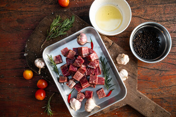 Sliced grilled thai steak served on white plate with grilled sliced lemon, tomatoes, garlic