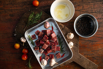 Sliced grilled thai steak served on white plate with grilled sliced lemon, tomatoes, garlic