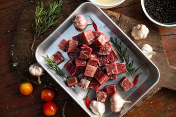 Sliced grilled thai steak served on white plate with grilled sliced lemon, tomatoes, garlic