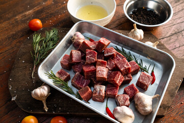 Sliced grilled thai steak served on white plate with grilled sliced lemon, tomatoes, garlic