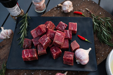 Sliced grilled thai steak served on white plate with grilled sliced lemon, tomatoes, garlic