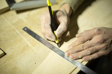 Marking on ruler with pencil. Drawing line on tree. Hands of carpenter.