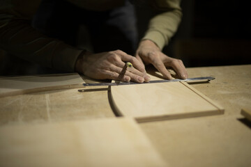 Marking on ruler with pencil. Drawing line on tree. Hands of carpenter.