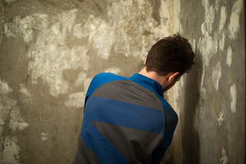 Fototapeta na wymiar Guy cleans wall. Home renovation. Wallpaper removal. Man cleans old paint. Concrete wall.