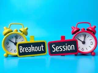 Alarm clock and wooden board with text Breakout Session on blue background.