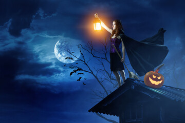 Naklejka premium Beautiful young woman in witches hat and costume