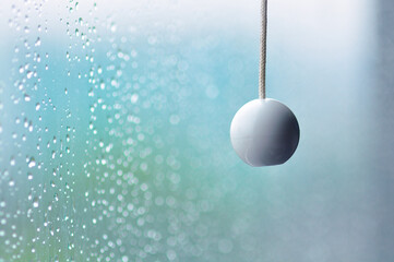 Beautifull Close-up Raindrops on the window with rope hanger Ball