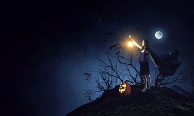Beautiful young woman in witches hat and costume