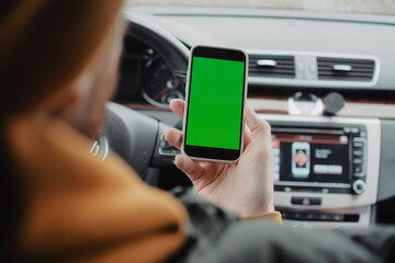 Millennial man drive the car and using mobile app , green screen