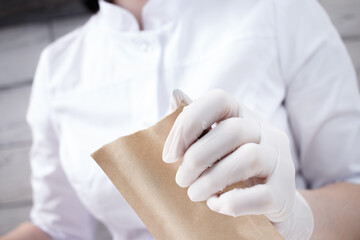 Professional manicurist opens a paper bag with sterile manicure tools