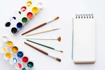 Top view paint, brushes and notepad for drawing. place under the text