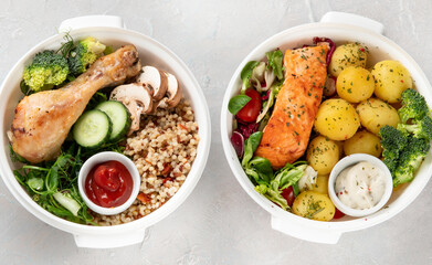 Healthy meal prep in lunch boxes on light background.