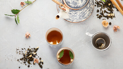 Fototapeta na wymiar Asian teapot with herbal tea on light background.