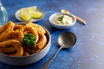 Homemade calamari with tartar sauce. Fresh homemade calamari with homemade tartar sauce and lemon.