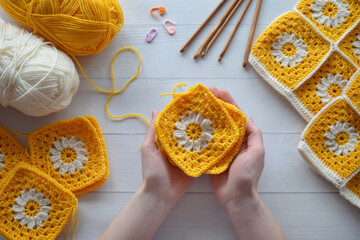 Obraz na płótnie Canvas Crochet handmade granny square pattern, crocheting supplies, assorted colored wool yarn, hook, knitting crocheting