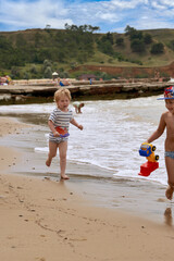 A little boy runs along the sandy beach along the seashore - 490997351