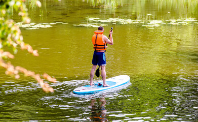A guy engaged in kayaking standing on a board
