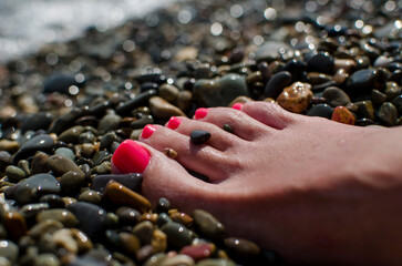 wet foot of a girl on a rocky beach
