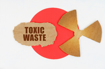 On the flag of Japan, the symbol of radioactivity and torn cardboard with the inscription - Toxic...