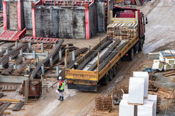 A large truck delivers material to the construction site. Supply of metal fittings for the...