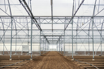Naklejka premium A greenhouse with fertilized soil and irrigation system.